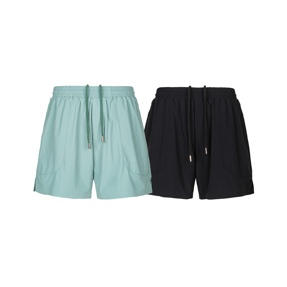 Front view of aqua and black shorts side by side, with elastic drawstring waists and curved pockets.