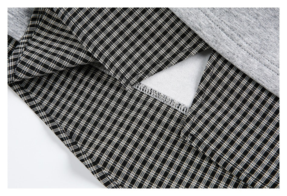 Close-up of black-and-white checked fabric seam and white inner layer beneath heather gray fabric.