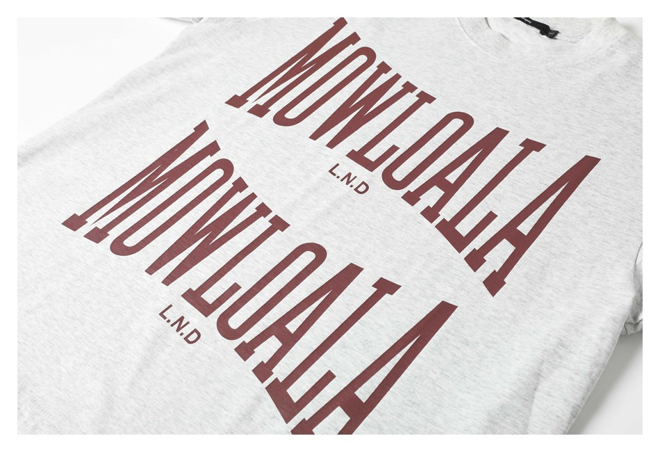 Close-up of a light gray heather T-shirt with large burgundy graphic lettering across the front.