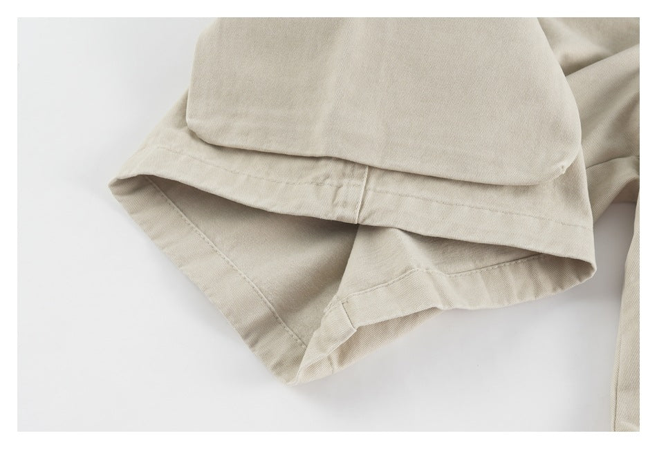Close-up of a beige shorts leg hem with visible stitching.