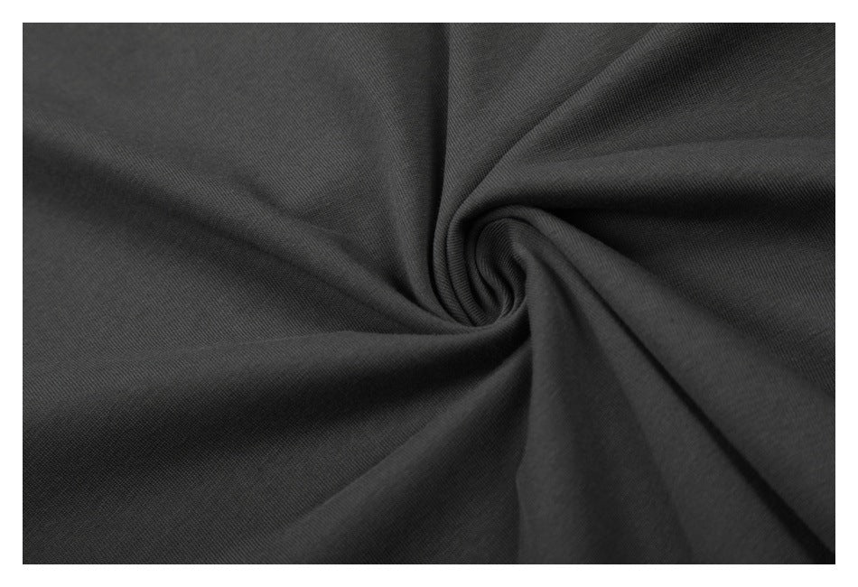 Close-up of dark charcoal fabric gathered into a twist, showing its surface texture.
