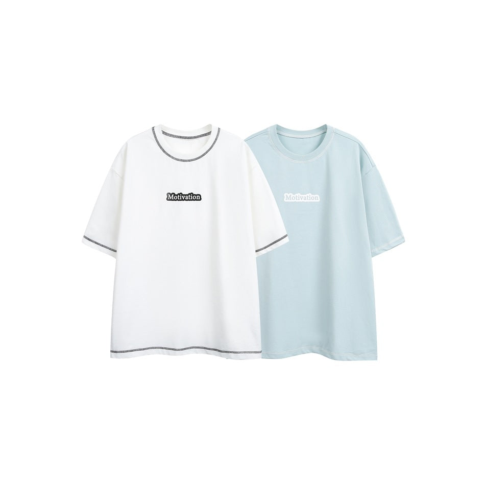White and pale blue T-shirts displayed side by side, each with a small chest graphic and contrasting trim details.