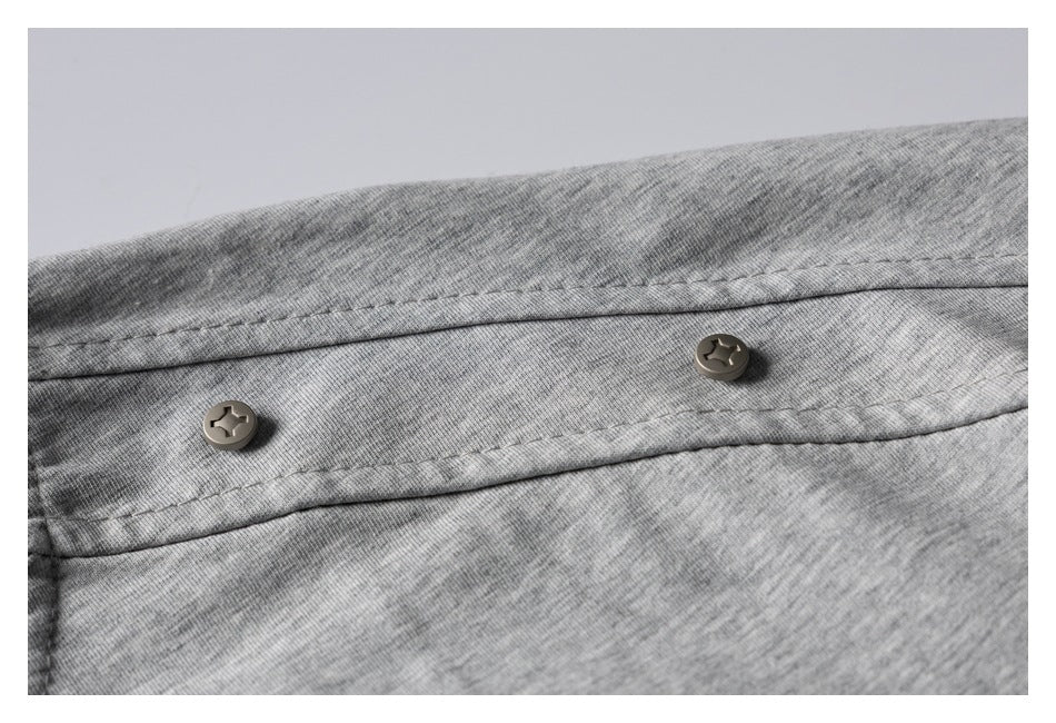 Close-up of two buttons on a stitched placket of a heather gray T-shirt.
