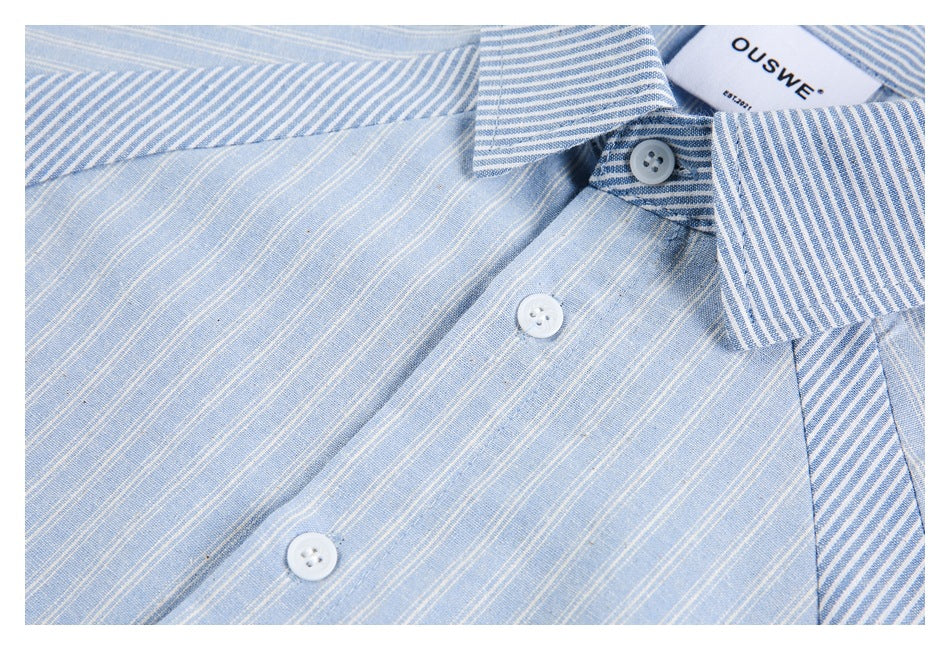 Close-up of the light blue striped shirt's collar, front buttons, and varied stripe patterns.