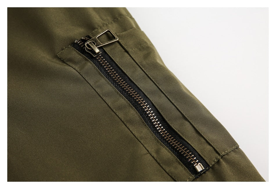 Close-up of a metal zipper set into an olive jacket panel.