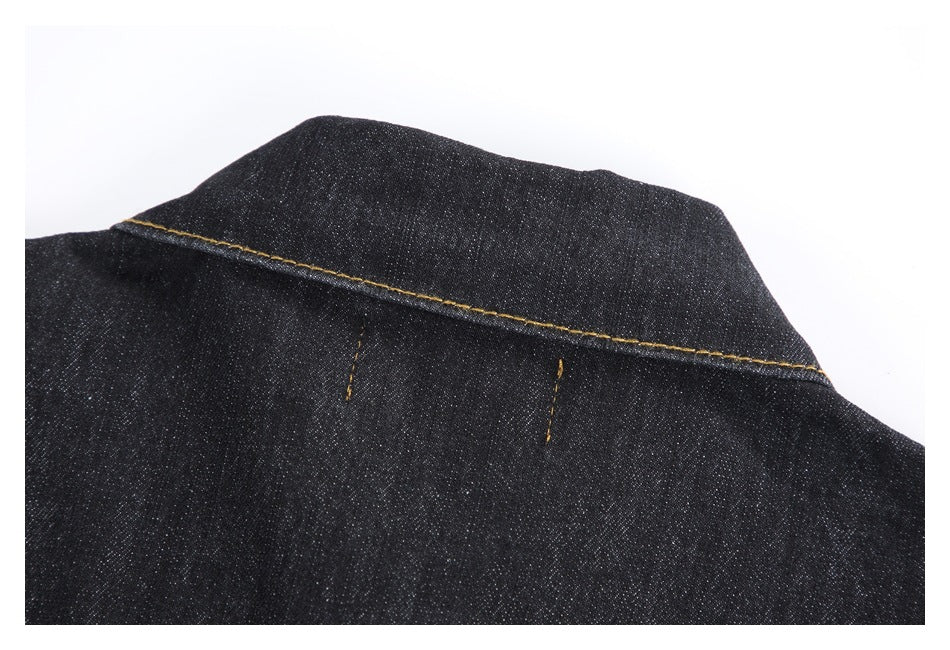Close-up of the dark denim jacket collar and upper back with gold stitching.