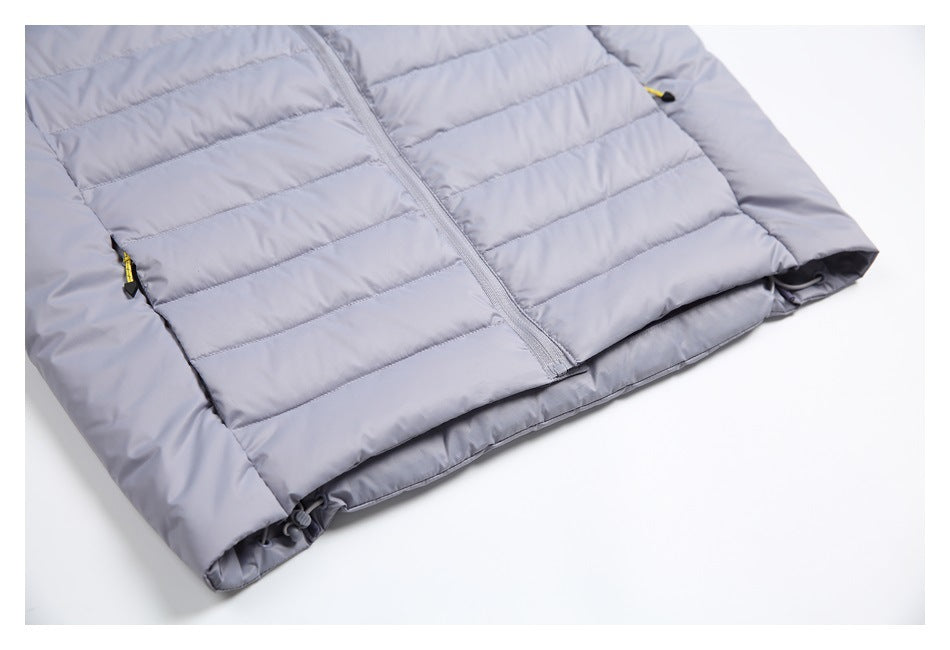 Close-up of the light gray vest's lower front, showing the center zipper, side pockets, and hem.