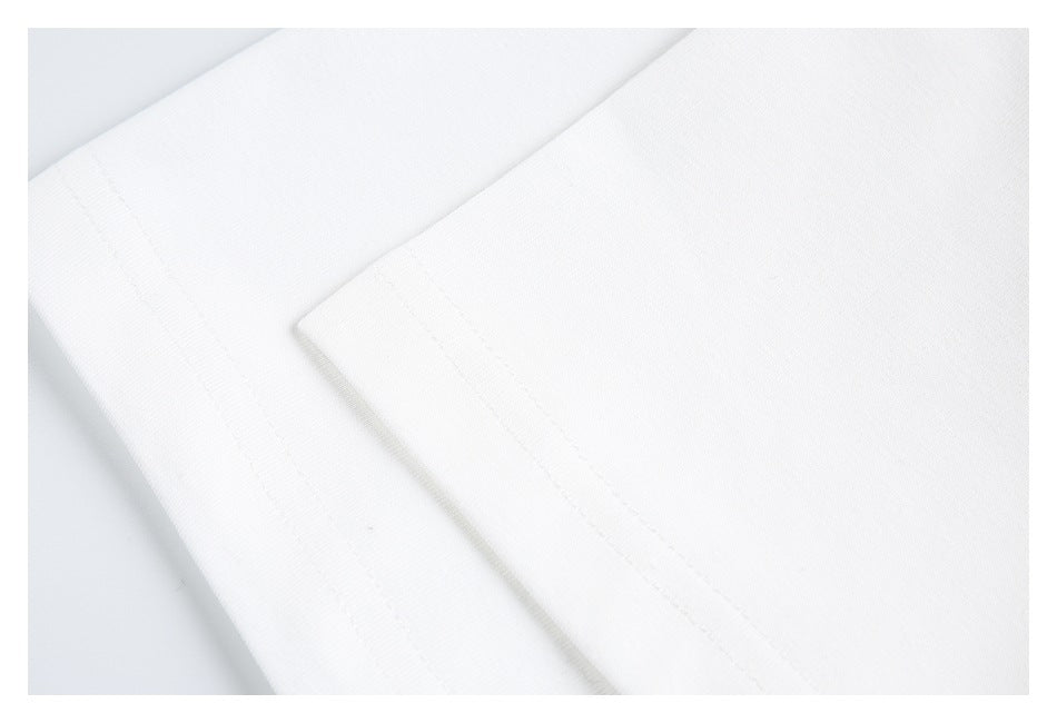 Close-up of white garment fabric and stitched edges at a folded seam.