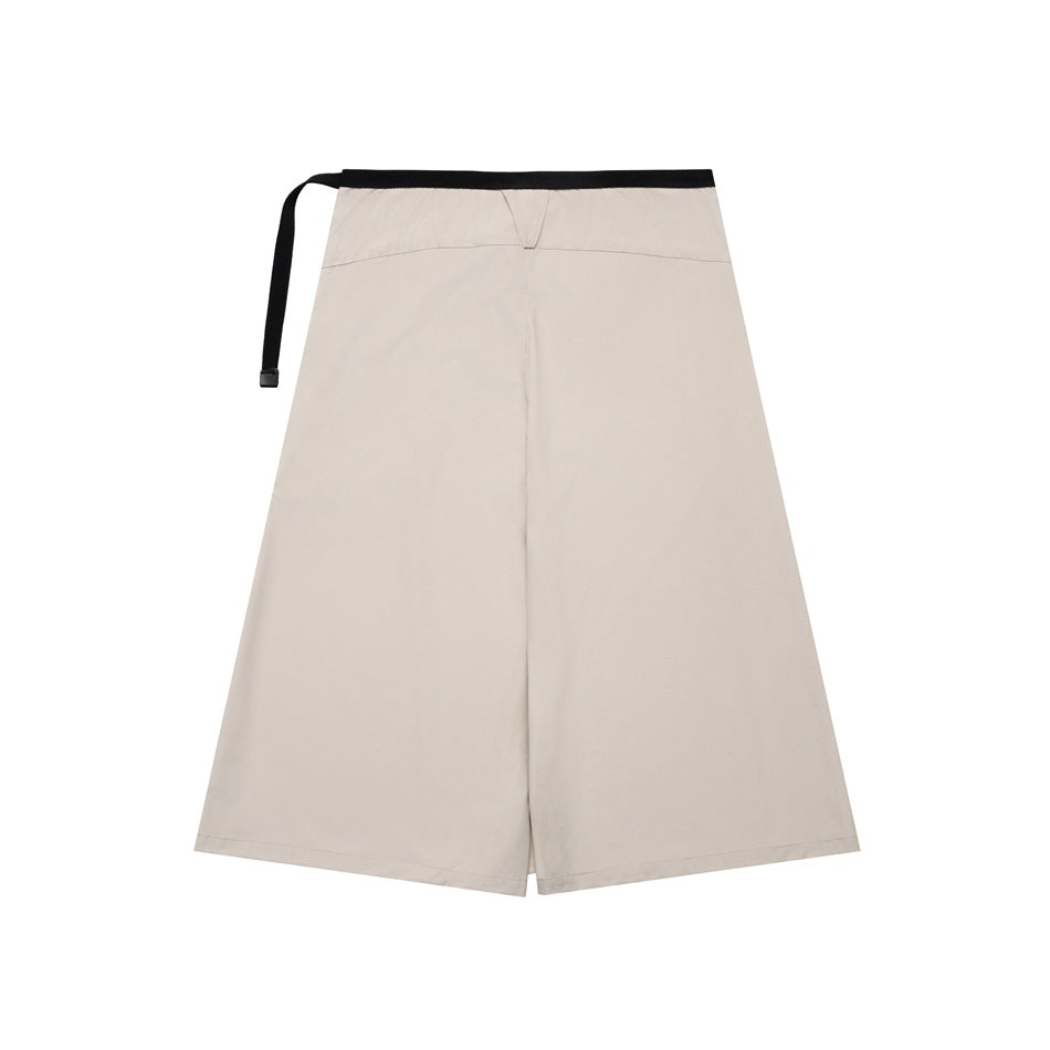 Light beige wrap-front skirt with a black webbing waist strap, shown flat against white.