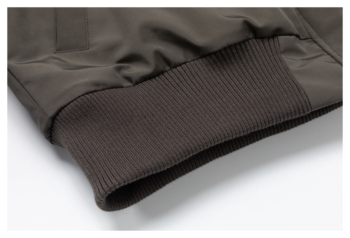 Ribbed knit waistband detail on a dark charcoal-brown jacket.