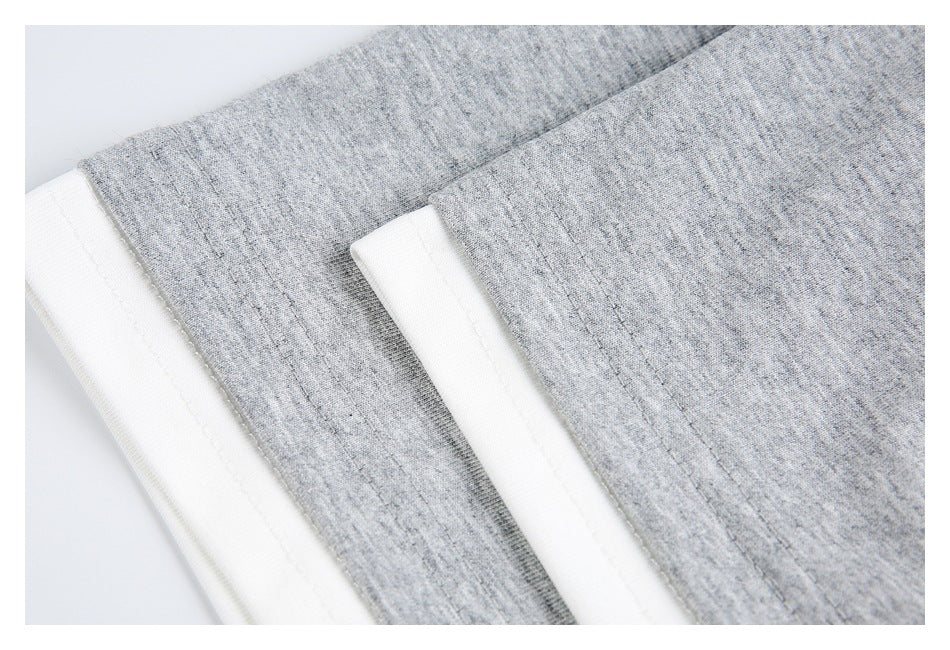 Close-up of two gray garment edges with white fabric trim and parallel stitching.