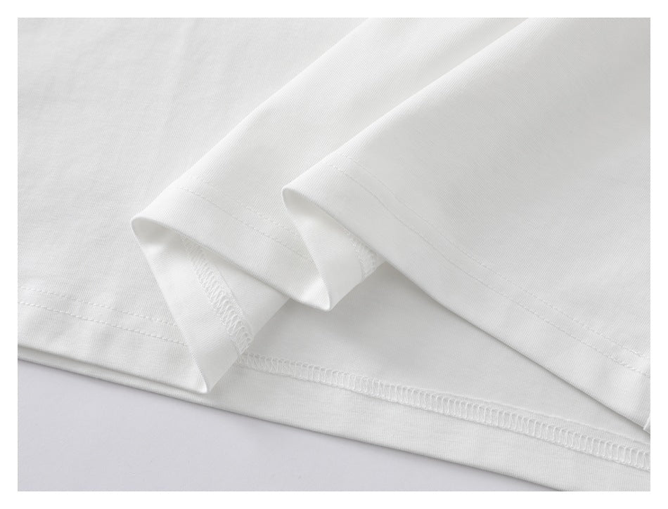 Close-up of the white T-shirt's folded hem and overlocked seam.