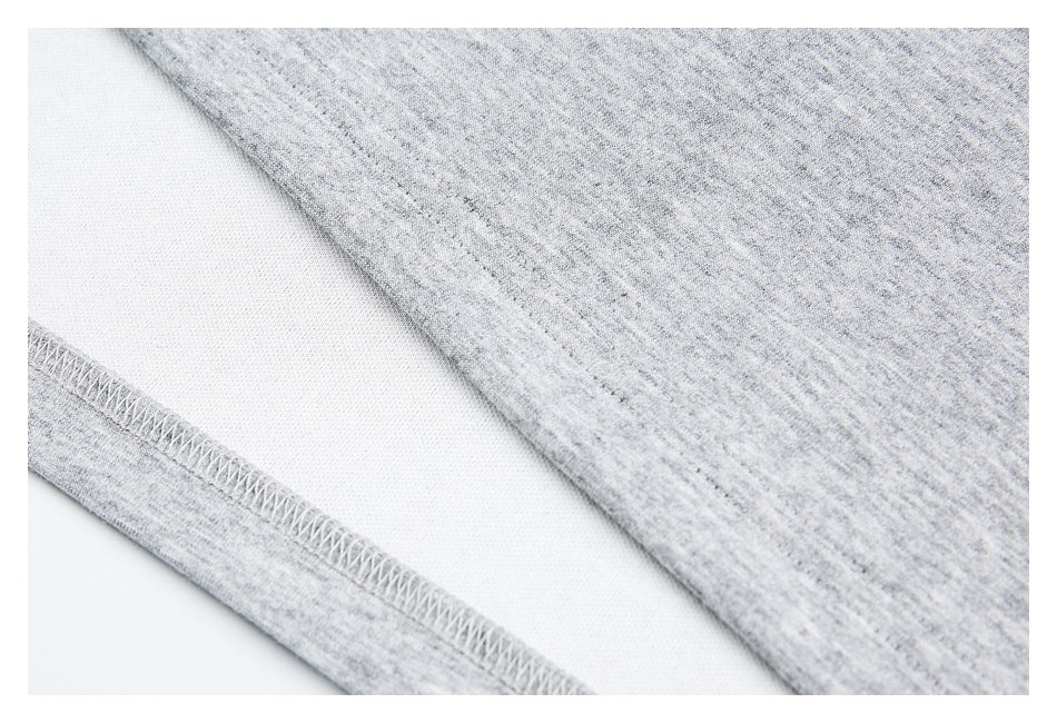 Close-up of gray heather knit fabric showing an overlock seam and the fabric's reverse side.