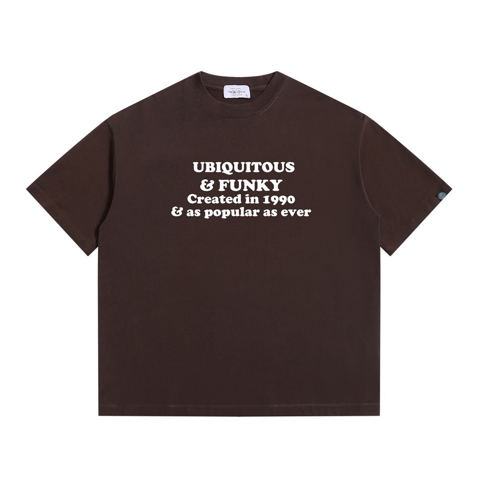 Dark brown short-sleeve T-shirt with white "Ubiquitous & Funky" slogan print on the chest, flat lay