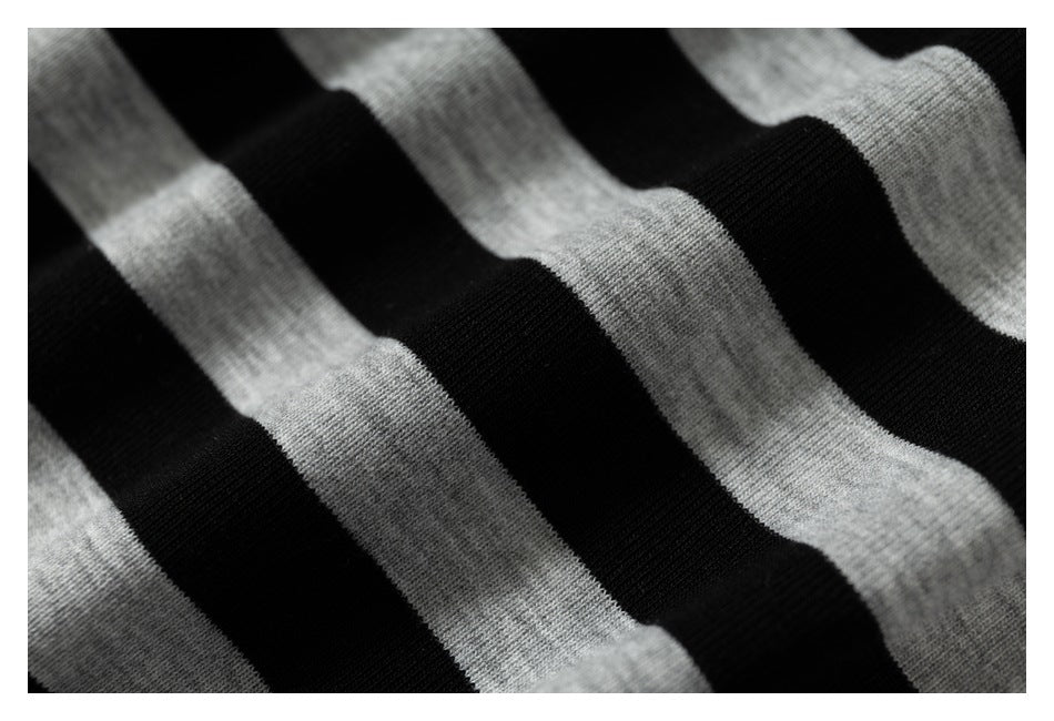 Extreme close-up of black and heather-gray striped fabric with soft folds.