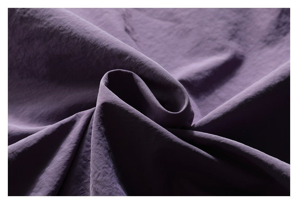 Close-up of folded purple jacket fabric showing its surface texture and drape.