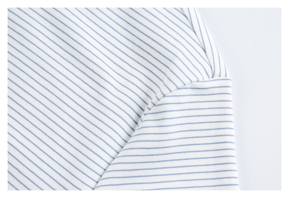 Close-up of the striped shirt's sleeve seam and hem, with blue stripes running in different directions.