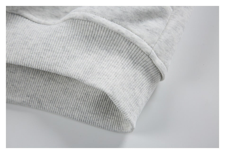 Close-up of the ribbed bottom hem on a light gray marled jacket.