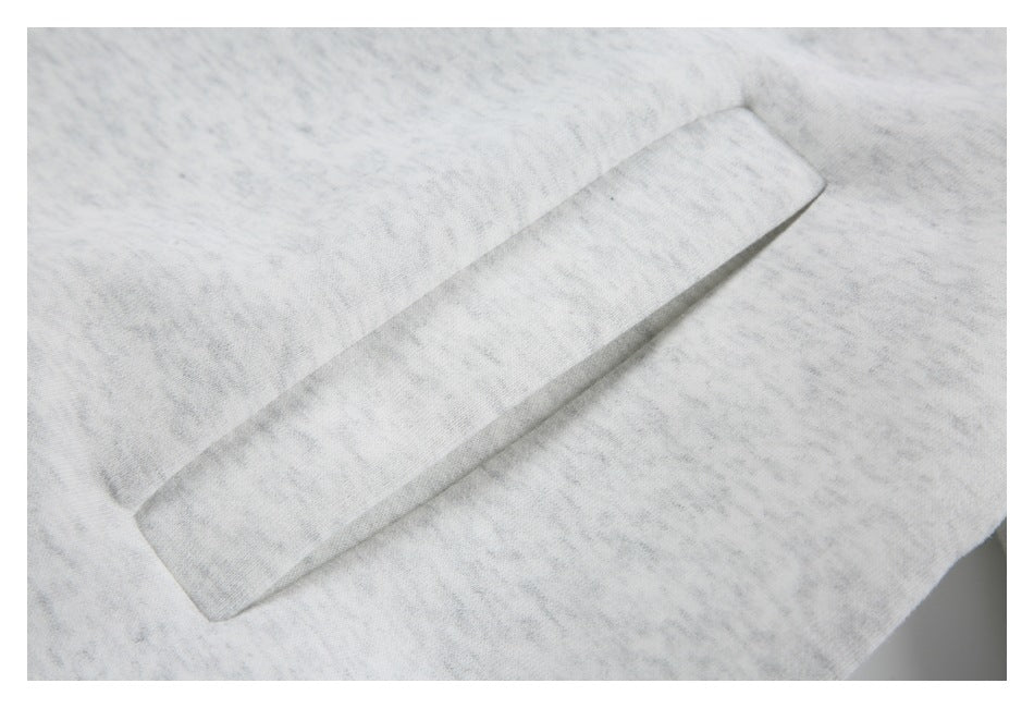 Close-up of a wide pocket opening on light gray marled jacket fabric.