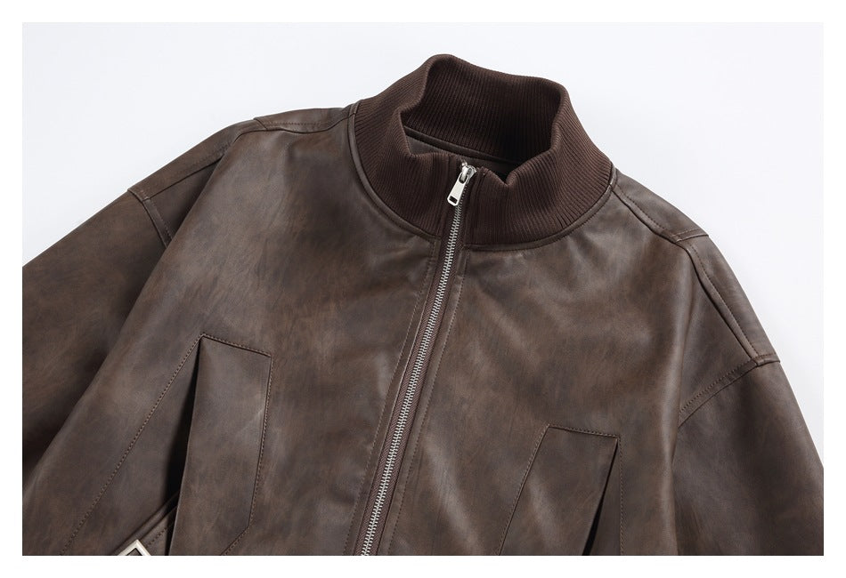 Close view of a dark brown jacket front with a ribbed stand collar, silver zipper, and angled pockets.