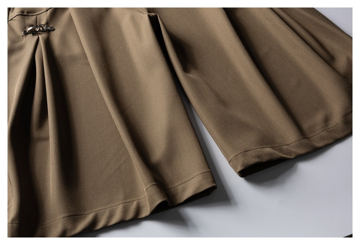 Close-up of brown trouser legs showing the clasp closure and stitched hems.