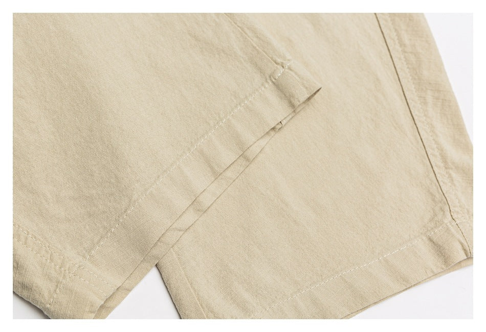 Close-up of beige bottoms showing the stitched hem and a small slit detail.