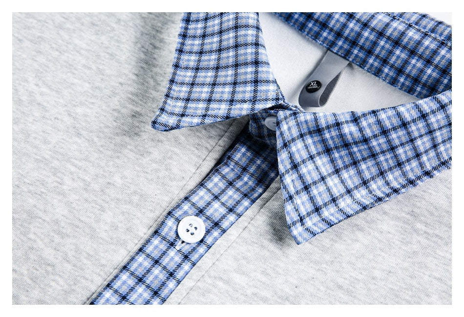 Close-up of a light gray shirt with a blue plaid collar and placket, white button, and XL neck label.