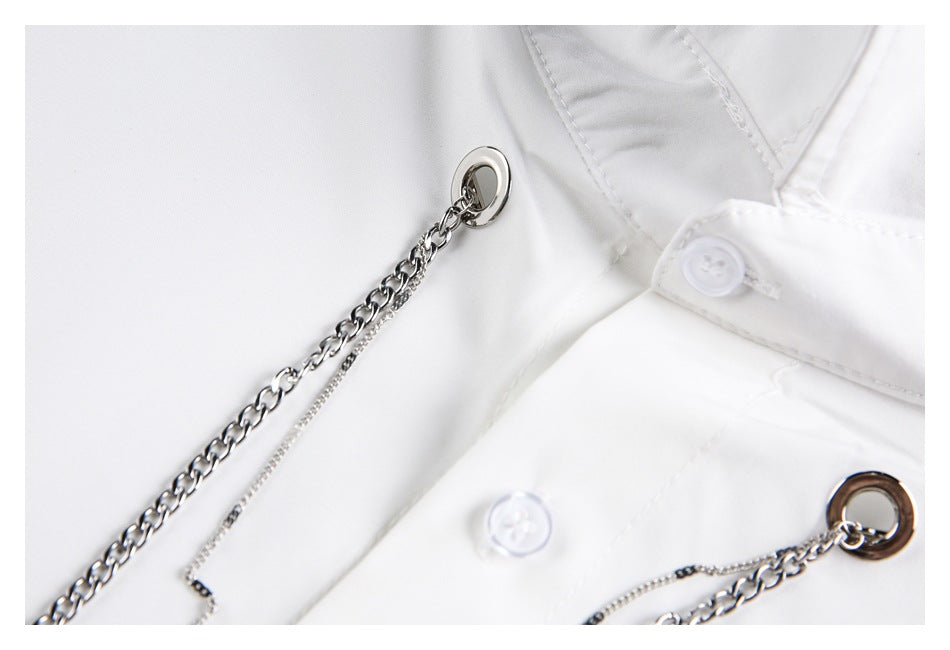 Close-up of silver chain attachments on a white shirt beside the collar and buttons.