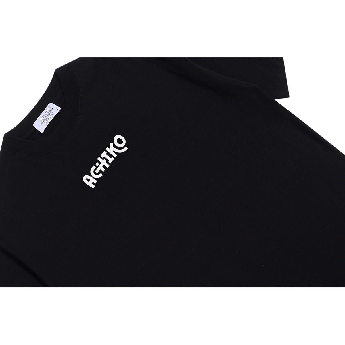 Close-up of a black crew-neck T-shirt with a small white stylized logo on the chest.