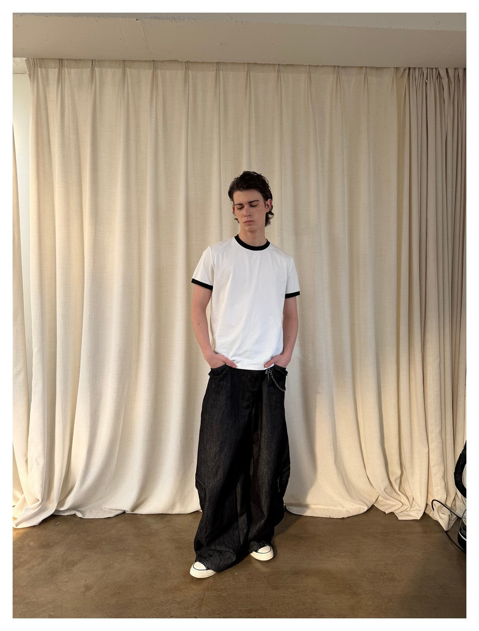 Full-length front view of a model wearing a white T-shirt with black collar and sleeve bands.