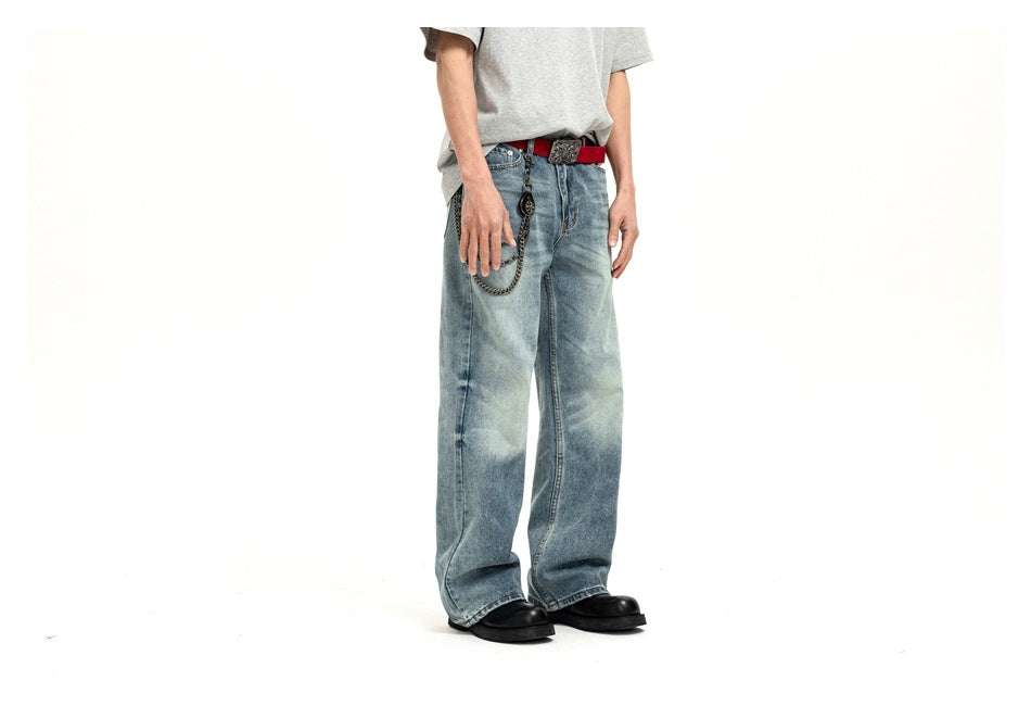 Cropped model in a three-quarter view wearing loose light-wash blue jeans with a red belt and hanging chain.