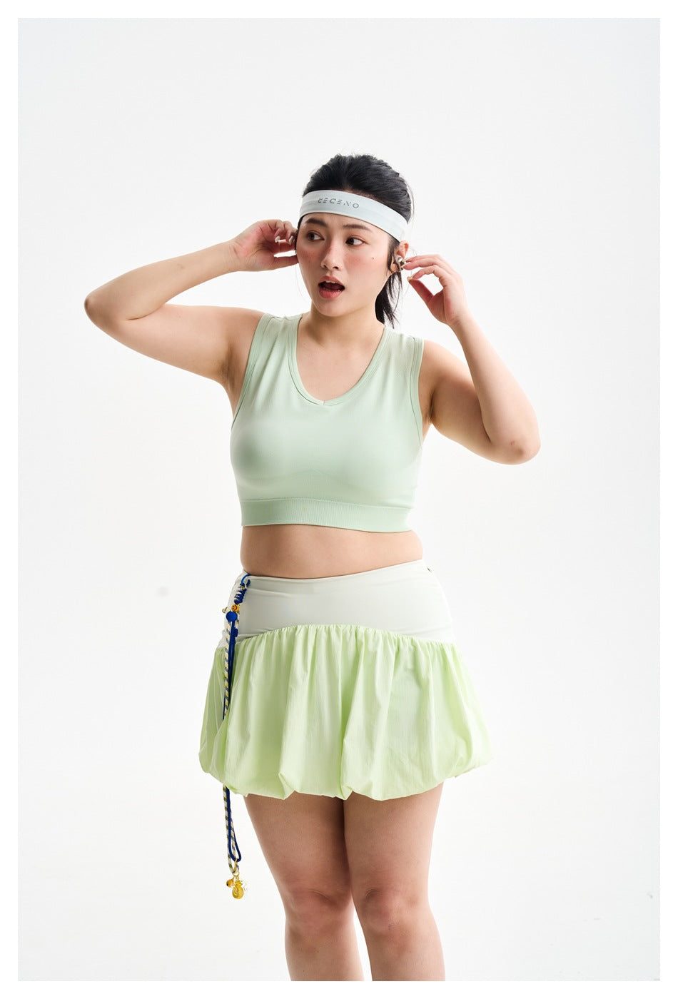 Closer view of a model wearing a pale mint crop top and light green bubble-hem skirt.