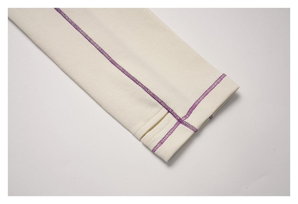 Close-up of the ivory sleeve cuff with purple contrast stitching.