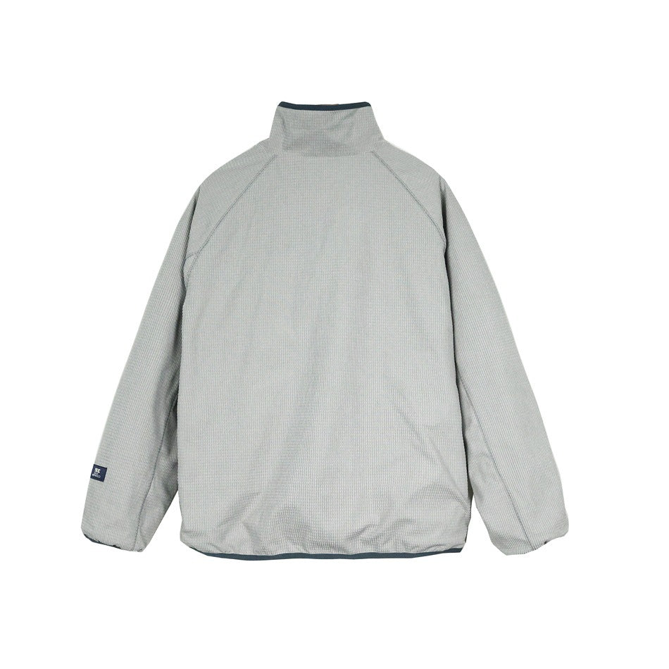 Back view of a light gray jacket with a stand collar and raglan sleeves; a small dark label is on one sleeve.