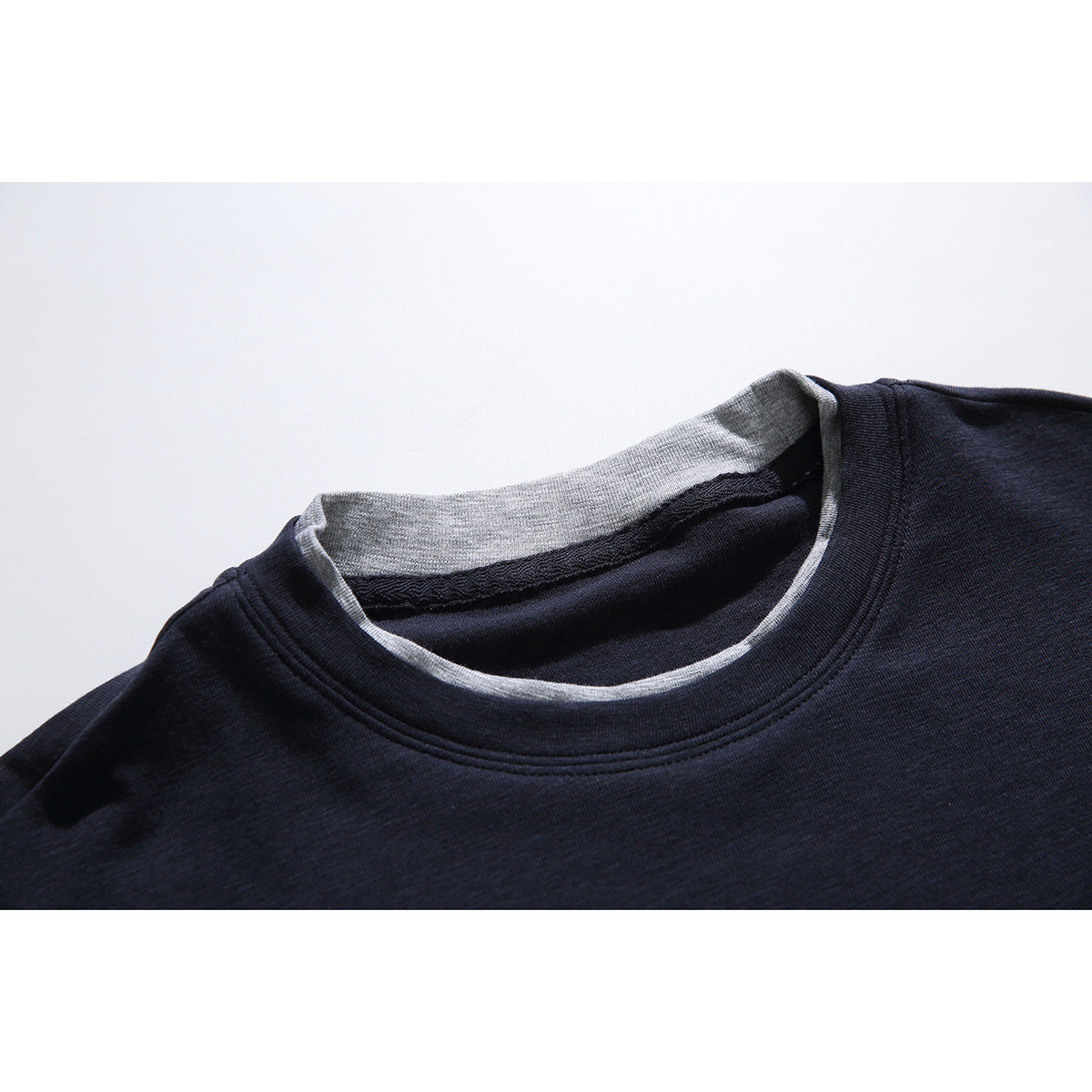 Close-up of a dark navy T-shirt neckline with a light gray inner collar and contrasting trim.