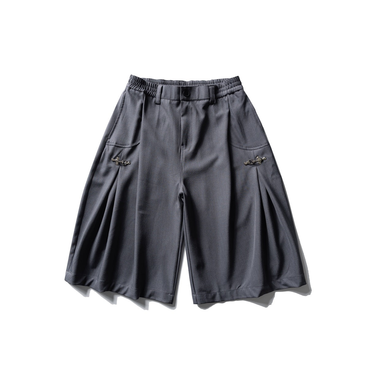 Gray knee-length wide-leg shorts with elastic waist, button closure, side pleats and metal clasp details, flat lay front view