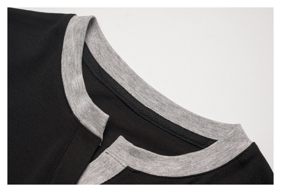 Close-up of a black shirt neckline with gray contrast ribbing.