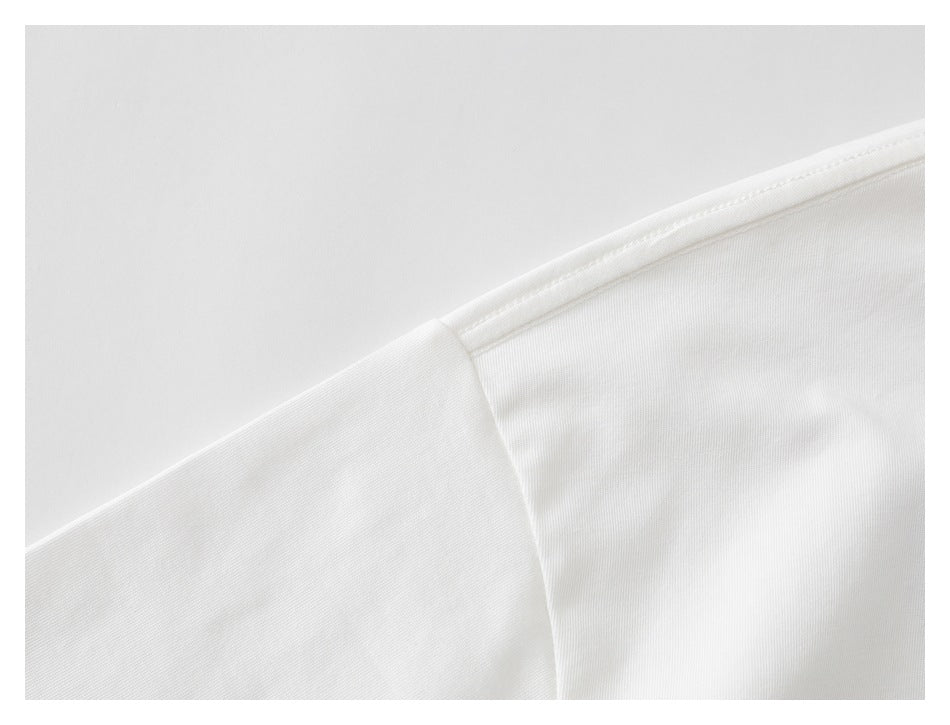 Close-up of a white garment shoulder seam and stitching.