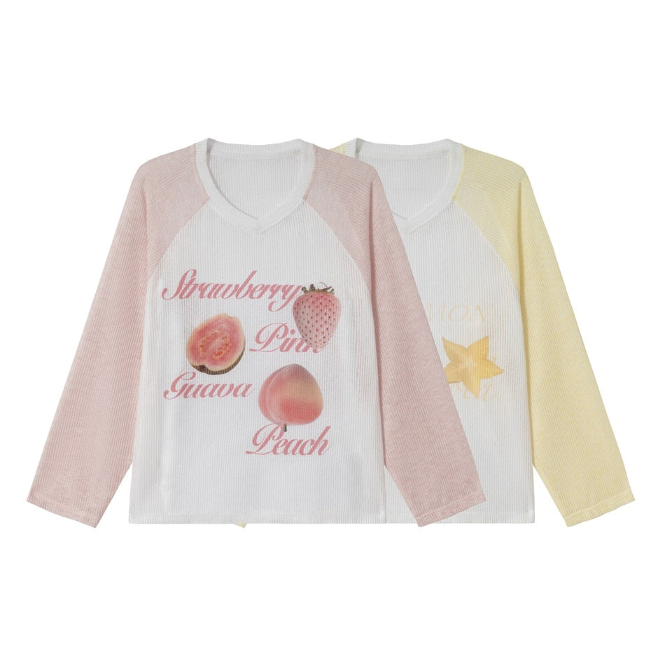 Two long-sleeve raglan V-neck tops: one with pale pink sleeves and fruit print, the other with pale yellow sleeves and a