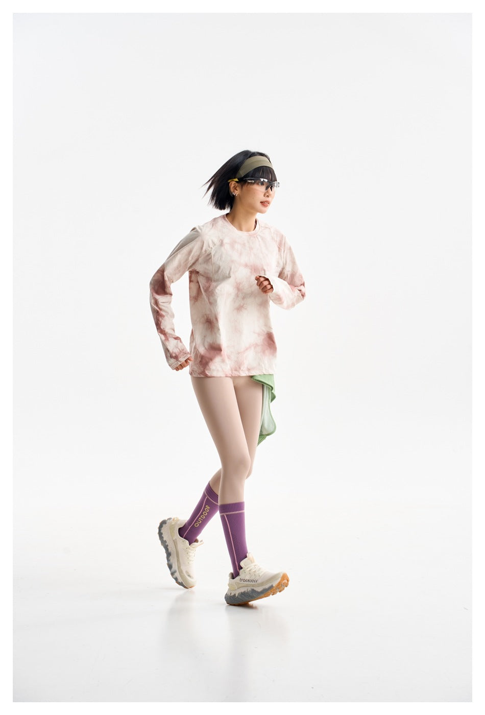 Model in a cream and dusty pink tie-dye long-sleeve top and beige leggings, shown in a running pose.