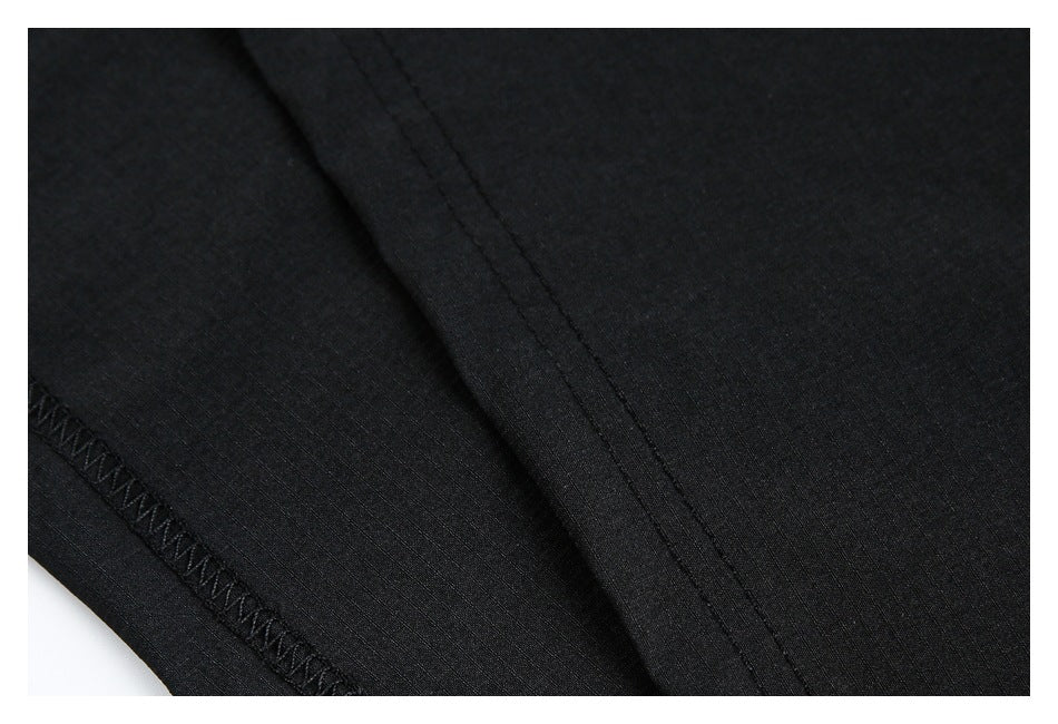 Close-up of black garment fabric showing a folded seam and zigzag stitching along the edge.