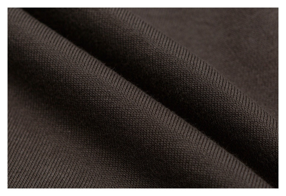 Macro view of the dark brown garment's knit surface and folded fabric.