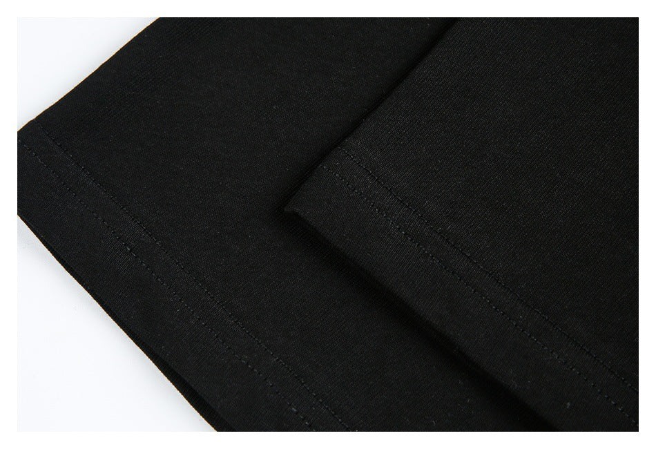 Close-up of black garment fabric showing a folded edge and parallel stitching.