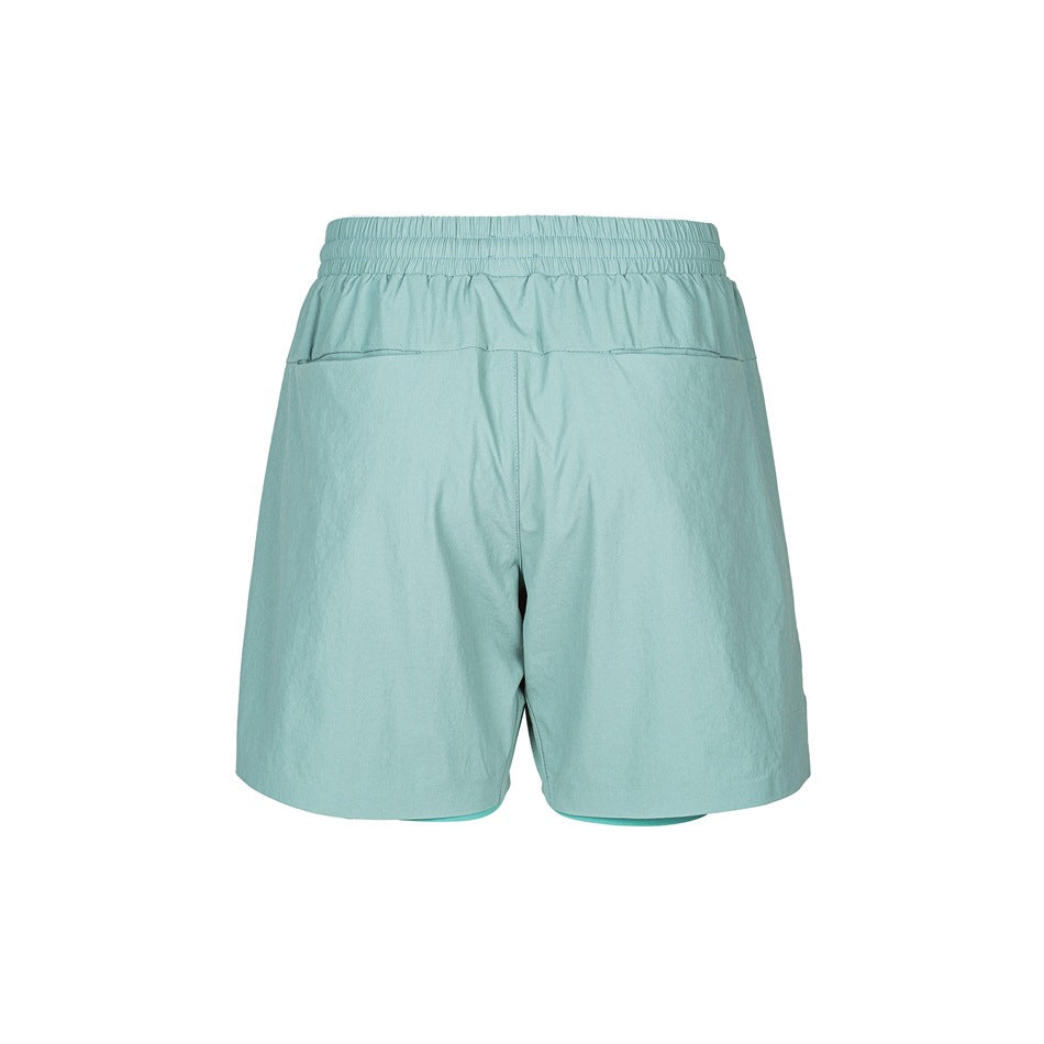 Back view of green shorts showing elastic waistband, back seam detail and inner layer at the hem