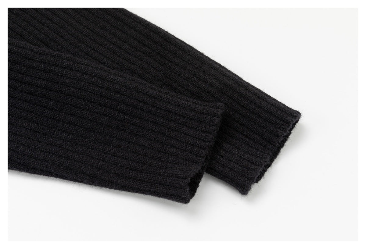 Close-up of black rib-knit sleeves with folded cuffs laid against a white background.