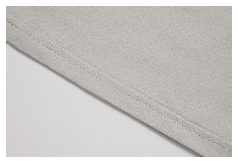 Close-up of the stitched hem on a light gray garment.