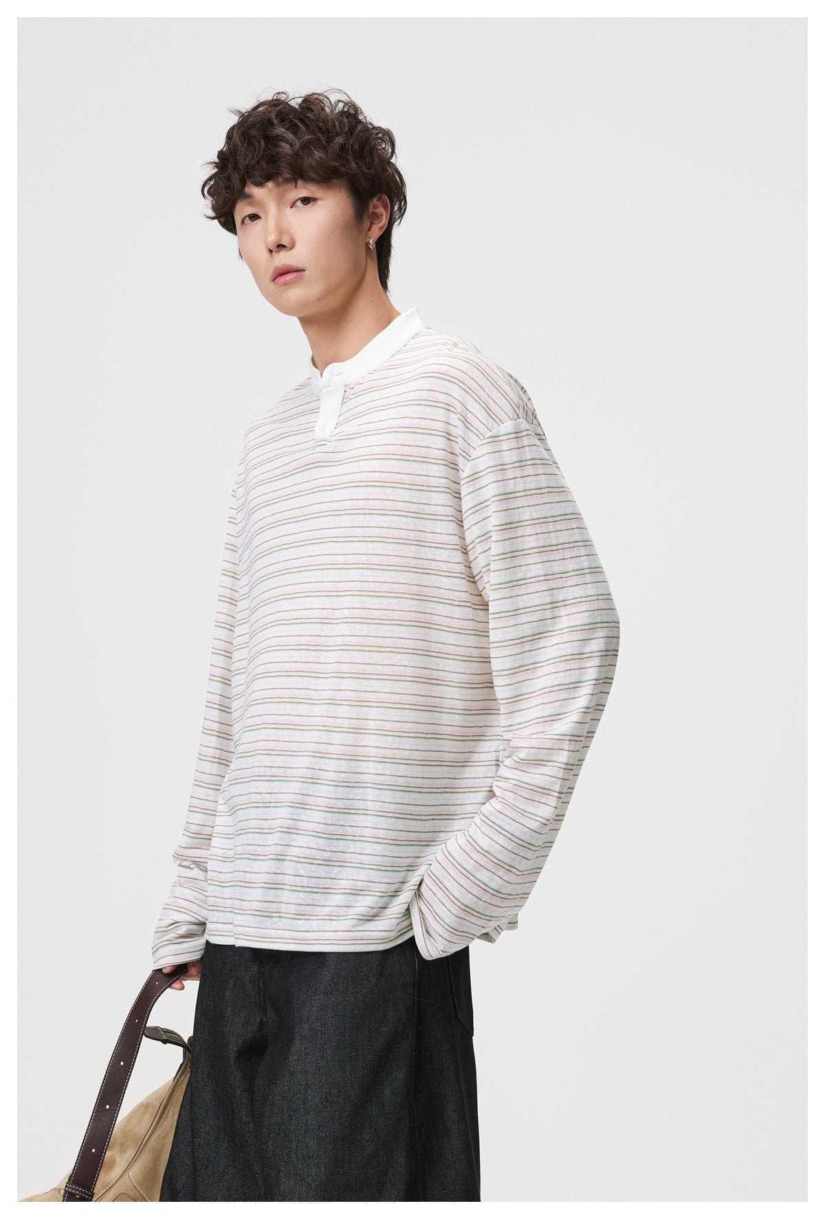 Closer front view of a model wearing a white fine-stripe top with a short stand collar and long sleeves.