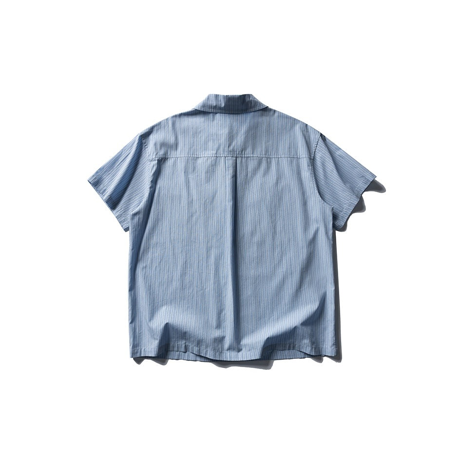 Back view of a pale blue short-sleeve shirt with fine stripes, a yoke seam, and a center pleat.