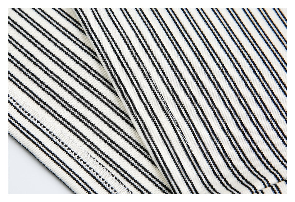Close-up of black-and-off-white striped fabric showing a stitched edge and seam.