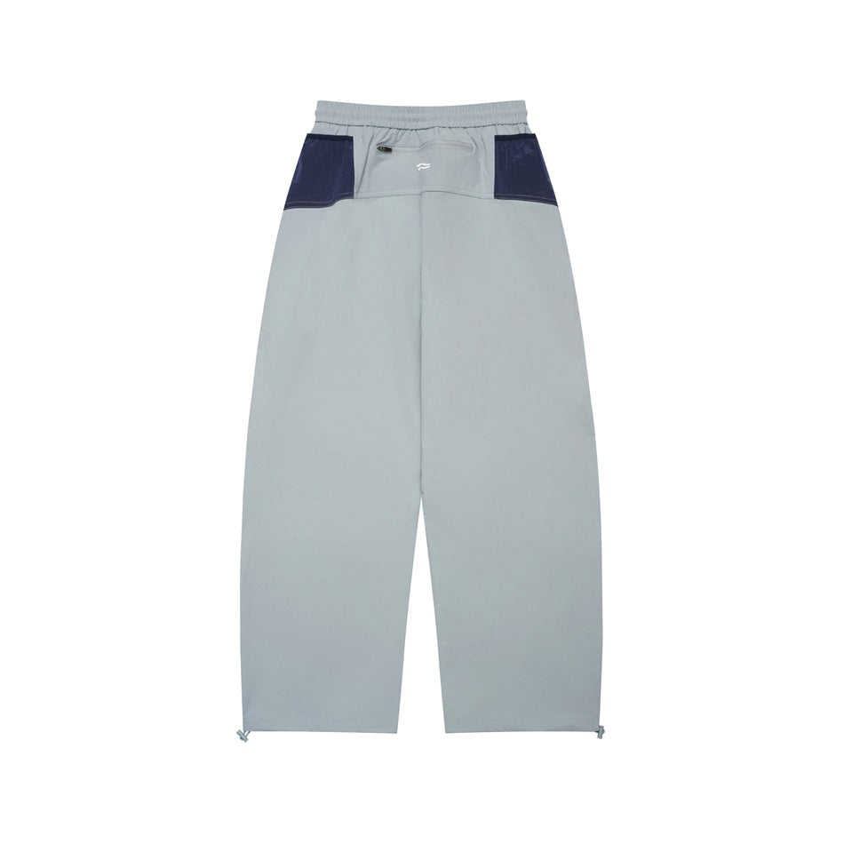 Full-length rear view of light gray pants with navy contrast panels, an elastic waistband, and a small zip pocket.